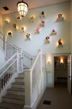 there are many shelves on the wall above the stairs