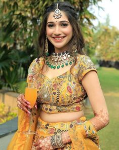 a woman in a yellow outfit holding a drink