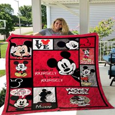 a woman holding up a mickey mouse quilt