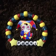 a close up of a beaded bracelet with a clown face on it's side