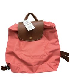 All of my listings are authentic Brand new with tag. No dusty bag! A timeless and durable nod to French style, Longchamp' nylon backpack stows any essentials for the très chic girl on the go. Top handle, adjustable backpack straps; Front flap with snap and zip closure; Packable, leather trim; Size: 11.5"H x 10"W x 3.75"D, 2" handle drop; Foldable Backpack, Tres Chic, Backpack Straps, D 2, Longchamp Le Pliage, French Style, Leather Trim, Leather Trims, Top Handle