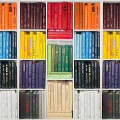 several rows of books are lined up in a bookcase with different colors and sizes