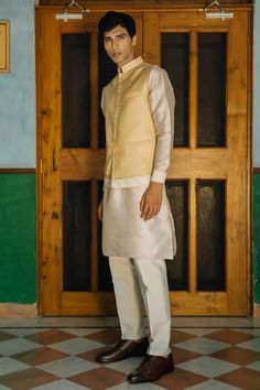 Beige silk bundi with contrasting hem, embroidered with sequins. Comes with kurta and pyjama. - Aza Fashions Designer Sleeveless Raw Silk Kurta, Designer Fitted Nehru Jacket With Embroidered Border, Fitted Nehru Jacket With Embroidered Border For Designer Wear, Festive Sleeveless Silk Kurta, Festive Fitted Nehru Jacket With Embroidered Border, Fitted Nehru Jacket With Embroidered Border For Festivals, Fitted Silk Nehru Jacket Straight Kurta, Fitted Silk Nehru Jacket, Fitted Silk Nehru Jacket For Festive Occasions