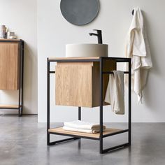 a bathroom with a sink, towel rack and mirror on the wall next to it