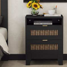 a black nightstand with sunflowers and books on it