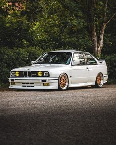 a white car parked in front of some trees