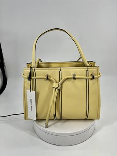 Calvin Klein Fatima Shoulder Bag. New with tags Top magnetic closure Silvertone hardware One inside slip pocket One inside zip pocket Textile lining Synthetic Imported SIZE Double top handles, 10" drop 12"W x 9"H x 5"D Yellow Purse, Yellow Purses, Yellow Handbag, Leather Shoulder Handbags, Shoulder Handbag, Magnetic Closure, Shoulder Handbags, Bags Handbags, Zip Pockets