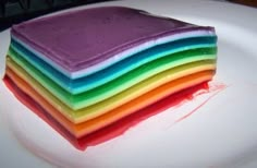 a stack of colorful cake sitting on top of a white plate