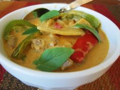 thai red curry with pork in a white bowl on a brown place mat and text overlay that reads, thai red curry with pork