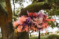 an arrangement of flowers hanging from a tree