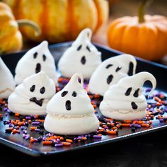 halloween desserts with white frosting and sprinkles on a black plate