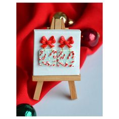 an easel with some candy canes on it and a christmas ornament