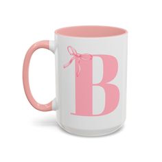 a pink and white coffee mug with the letter b on it's front side