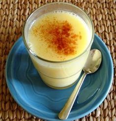 a blue plate topped with a cup filled with liquid