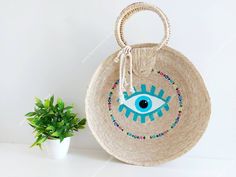 I love Mexico celebrates the native crafts of Mexico and the artists that produce them, enabling them and their communities to get recognized for their talented work and achieve economic stability for their families. This listing is for this bag shown on the pictures, hand made of palm leaf and dyed with natural vegetable dye. The evil eye symbol is commonly used as a protection. Approx measurements : 14 inches diameter, please see photos for measurements. The bag is very nicely made, strong and Traditional Palm Leaf Straw Bag For Summer, Artisan Handwoven Straw Bag For Gifts, Artisan Handwoven Straw Bag Gift, Handmade Palm Leaf Straw Bag For Beach Season, Handmade Palm Leaf Straw Bag For Vacation, Handmade Summer Straw Bag For Festival, Natural Colored Handmade Artisan Straw Bag, Traditional Beach Bag As Summer Gift, Artisan Handmade Natural Straw Bag