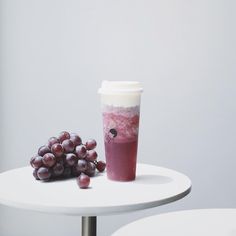 a table with grapes and a cup on it