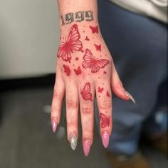 a woman's hand with red butterflies on it and the word happy written in silver