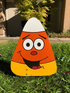 an orange and white cone shaped object sitting in the grass