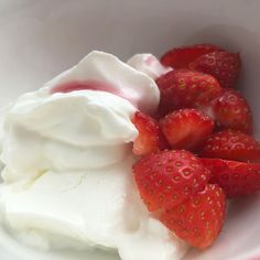 strawberries and whipped cream in a white bowl