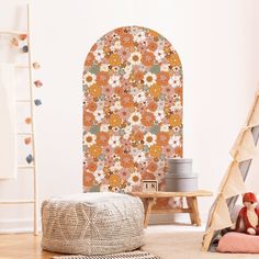 an orange and pink flowered wallpaper in a child's room with a teddy bear