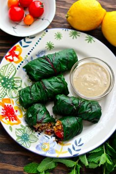 some food that is on a plate near lemons and cherry tomatoes with dipping sauce