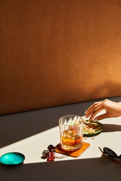 a woman sitting at a table with a glass and some food on top of it