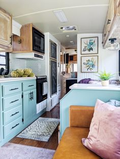 the interior of an rv with blue cabinets and wood flooring is shown in this image