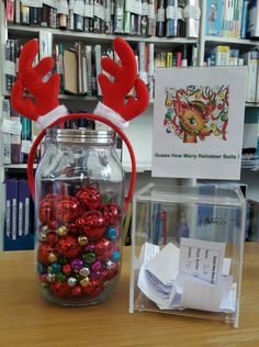 a glass jar filled with candy and reindeer antlers on top of a wooden table