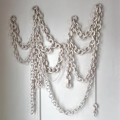 a white wall with chains hanging from it's sides