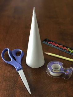 a pair of scissors, tape and some other crafting supplies on a wooden table