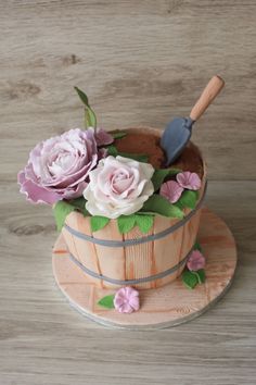 a cake decorated with flowers in a wooden bucket