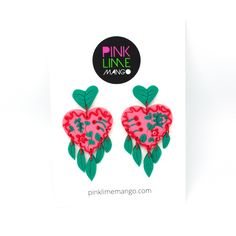 two pink and green heart shaped earrings on top of a white card with the words pink link