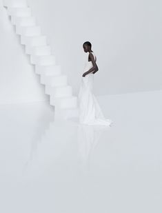 a woman standing in front of a white staircase