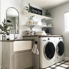 a washer and dryer sitting in a room next to a window with shelves on the wall