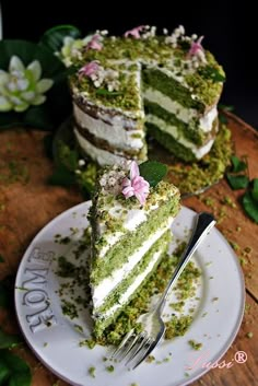 a piece of cake on a plate with a fork in front of it and flowers