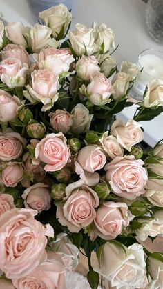 a bouquet of pink roses sitting on top of a table