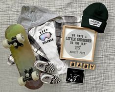 a skateboard, hat, and other items laid out on top of a bed