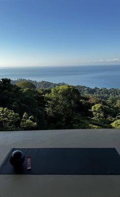 a yoga mat on top of a table with a view of the ocean in the distance