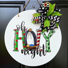 a christmas door hanger with the word joy on it and a green bow hanging from it