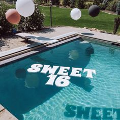 a pool with balloons floating in it and the words sweet 16 written on the side