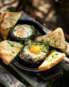 an iron skillet filled with bread and fried eggs on top of eachother