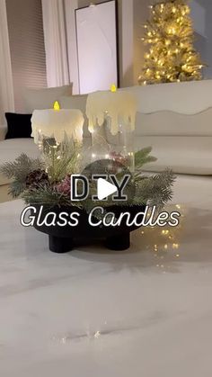 two candles are sitting on a table with christmas decorations in front of the candle holders