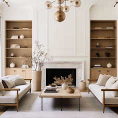 a living room filled with furniture and a fire place under a chandelier in front of a fireplace