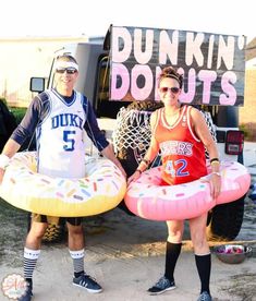 two people standing next to each other holding giant inflatable toys and wearing basketball gear