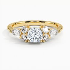 a yellow gold ring with three stones in the center and two diamonds on each side