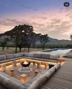 an outdoor living area with couches, tables and fire pit in the middle of it