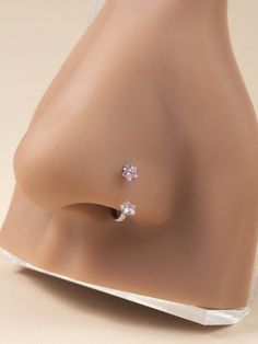 a pair of pink diamond earrings on top of a plastic mannequin