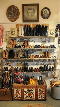 there are many shoes and purses on the shelves