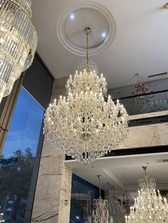 a chandelier hanging from the ceiling in a room with marble floors and walls