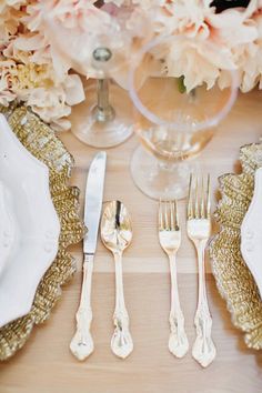 the table is set with silverware and flowers